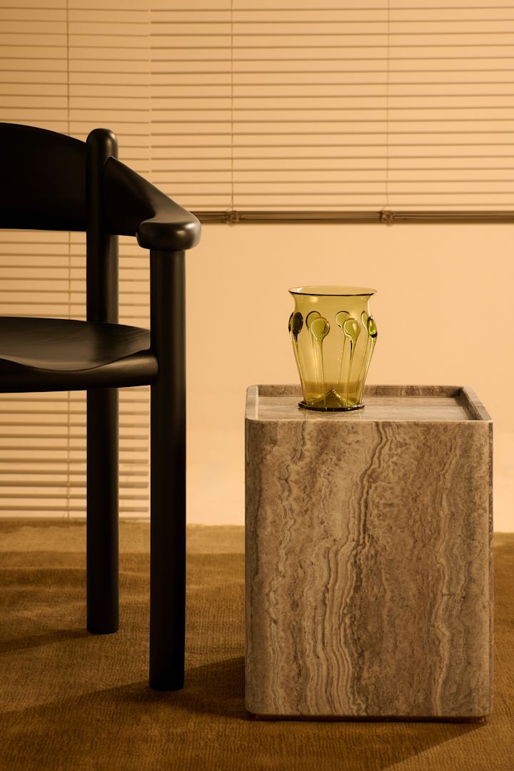 Los cuadros y las rayas son una de las grandes tendencias según las tendencias de diseño de interiores de otoño de 2024. Aquí se ve a una mujer sentada en un sillón sosteniendo una taza de cuadros azules de Byon.