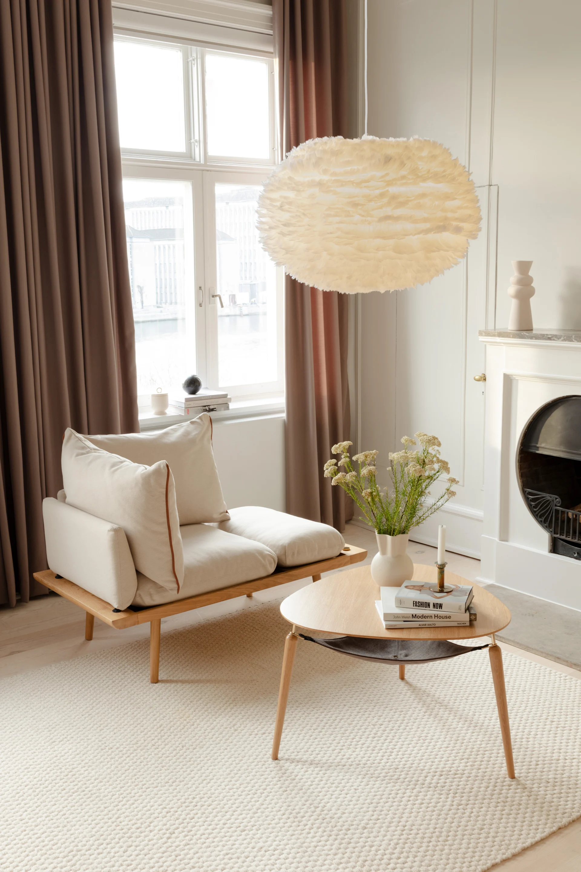 En un salón escandinavo y minimalista, cuelga la lámpara de techo Eos de plumas de Umage.