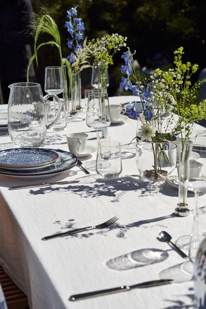 Aporta un toque extra a la mesa de verano con una colección de jarrones y flores azules y blancas.