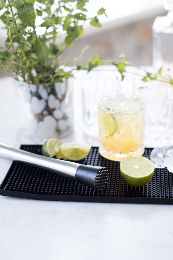 Cócteles sin alcohol: caipirinha virgen con lima y azúcar moreno sobre un tapete de bar.