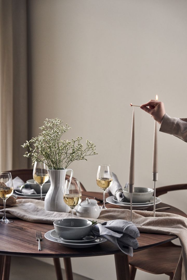 Aquí puedes ver una elegante idea para poner la mesa con platos y cuencos Swedish Grace en color Mist con velas beige de Ester y Erik. 
