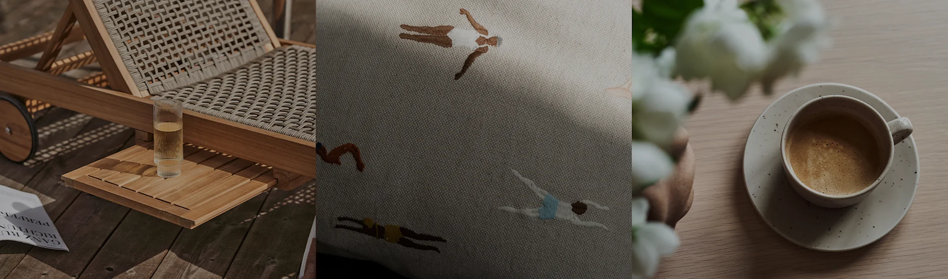 Una tumbona con una bebida, un cojín bordado con nadadores y una taza de café con flores blancas.