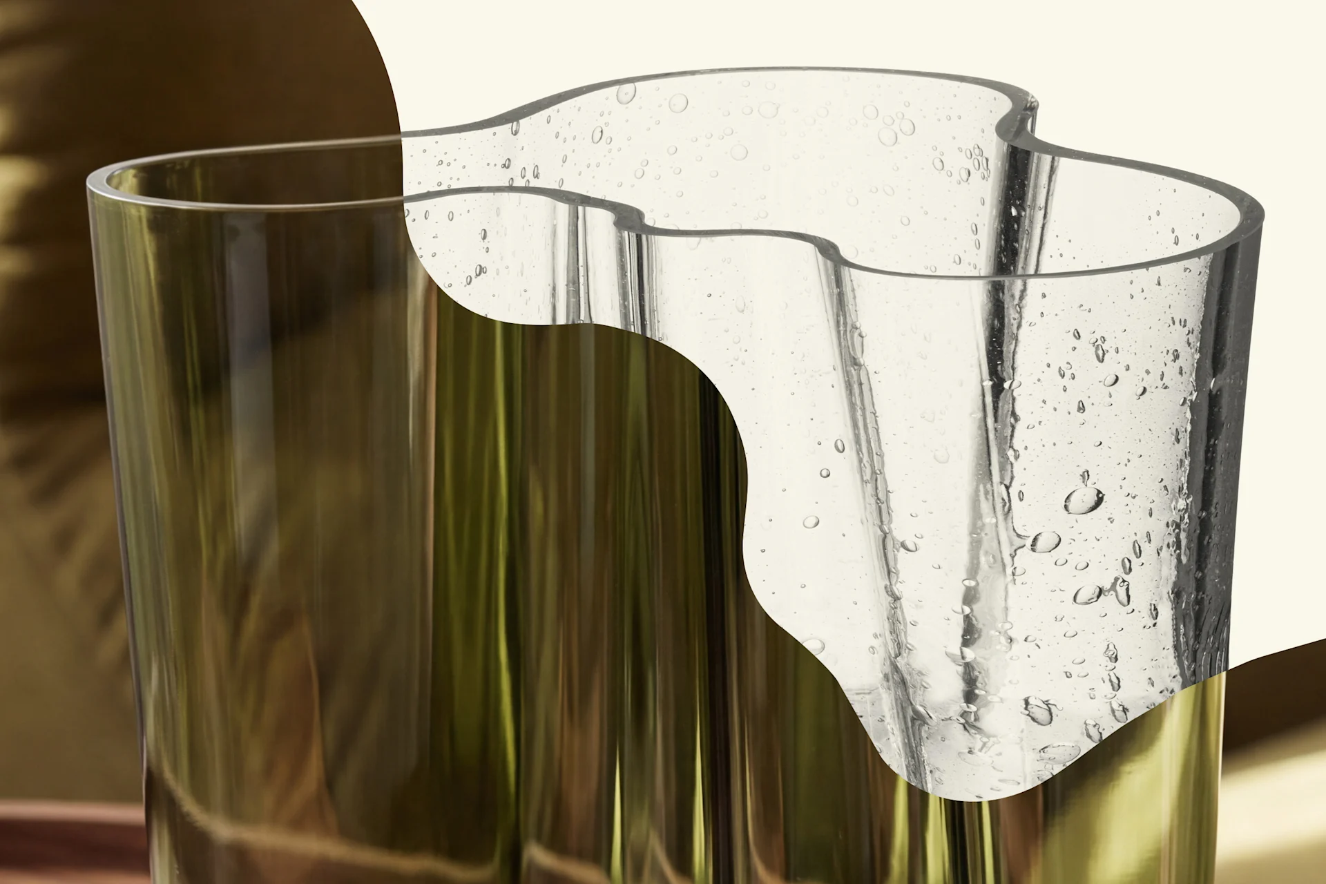 Dos jarrones de cristal: uno cilíndrico verde oliva, uno transparente y ondulado con burbujas de aire.