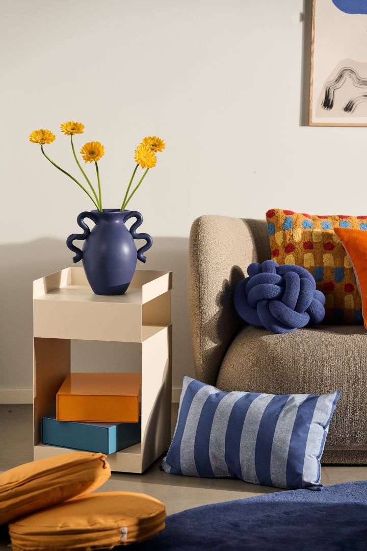 Las tendencias de color para interiores en 2024 incluyen tonos azules, naranjas y ámbar, todos presentes aquí en un ambiente colorido de sala de estar.