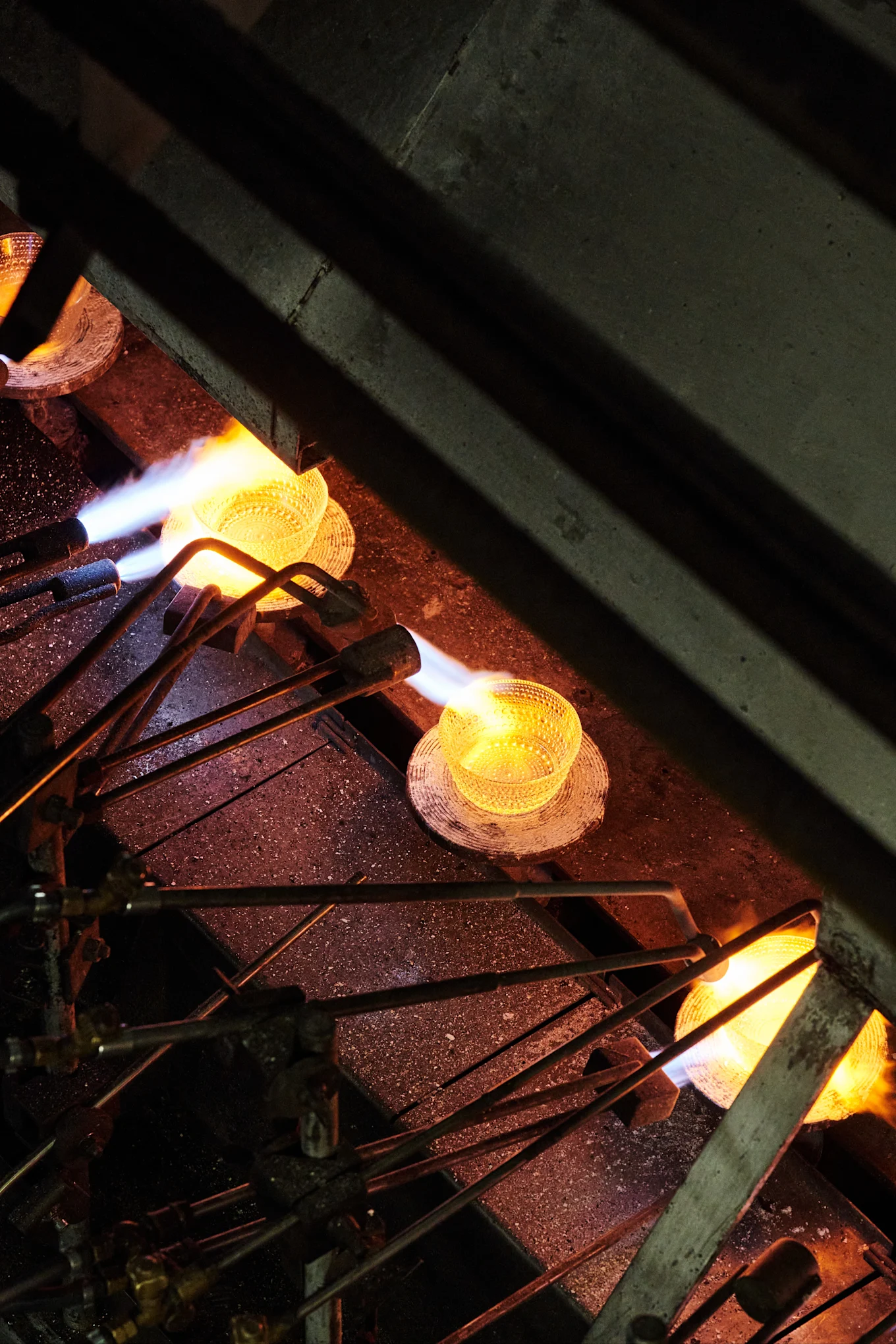 El cuenco Kastehelmi se calienta en una línea de producción de la fábrica de vidrio de Iittala en Finlandia.