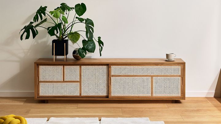 Los elementos de ratán del aparador Air de Design House Stockholm lo convierten en la decoración boho perfecta. Aquí se ha decorado con una gran planta.