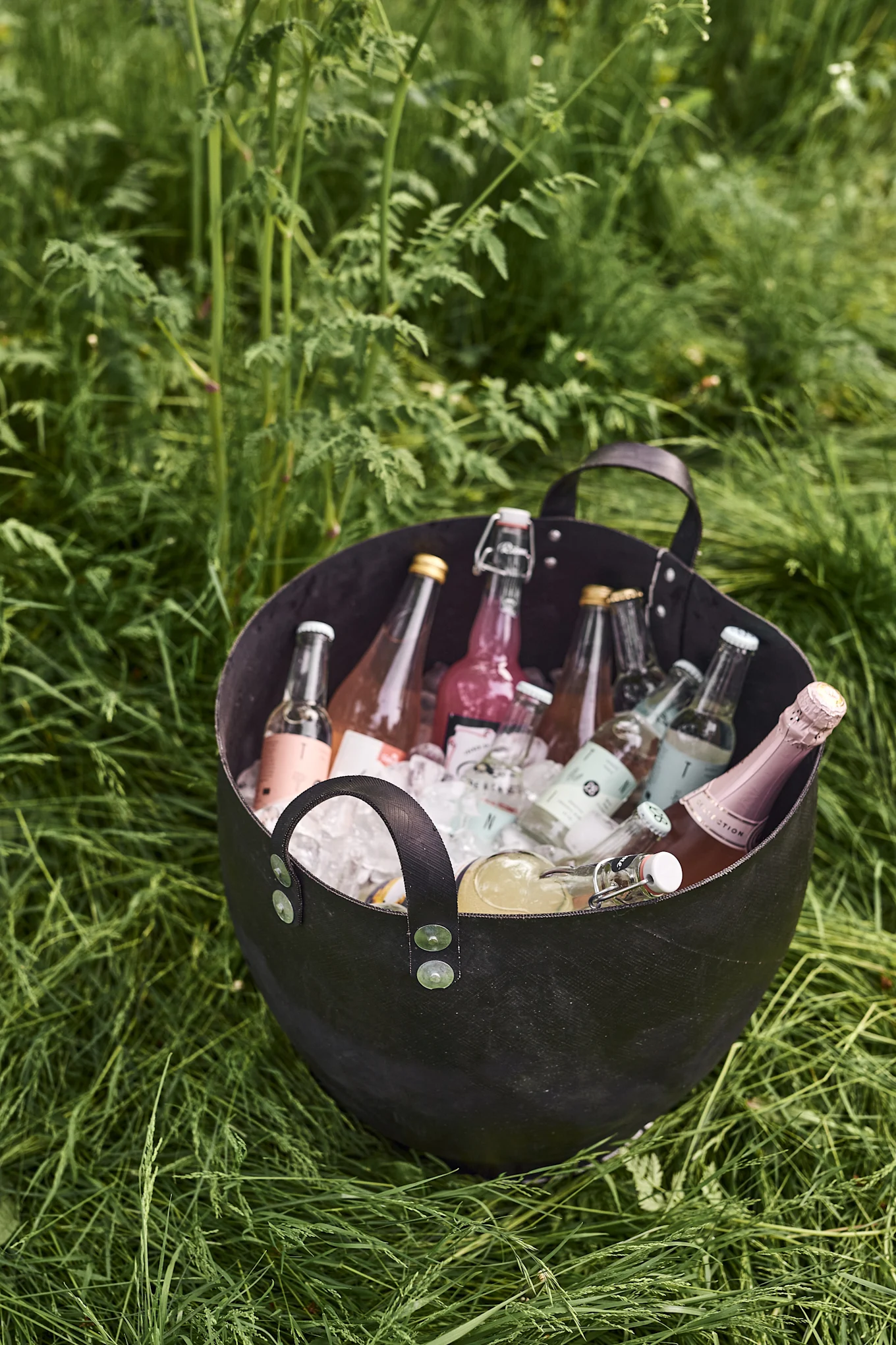 Descubre nuestras ideas para una fiesta en el jardín y llena una cubitera con hielo picado para enfriar las bebidas de tus invitados. Aquí puedes ver la práctica cesta Dacarr de Muubs.