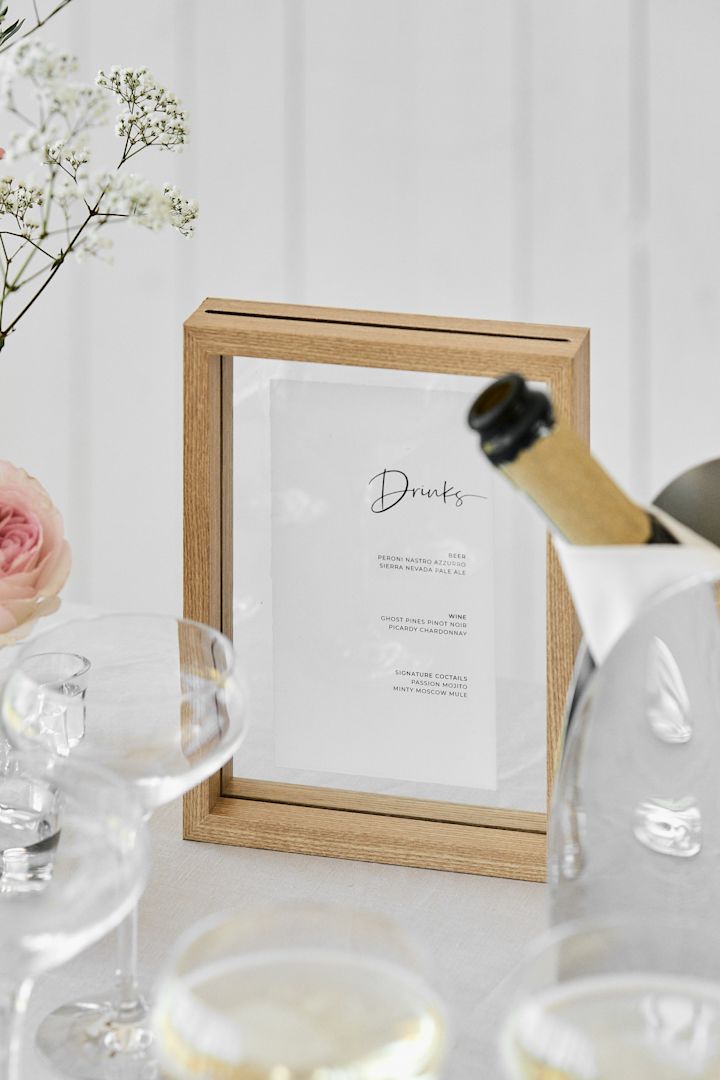 Una idea de boda única ideal para bodas al aire libre. Aquí ves un primer plano de una carta de
bebidas en un marco de madera de Urban Nature Culture.