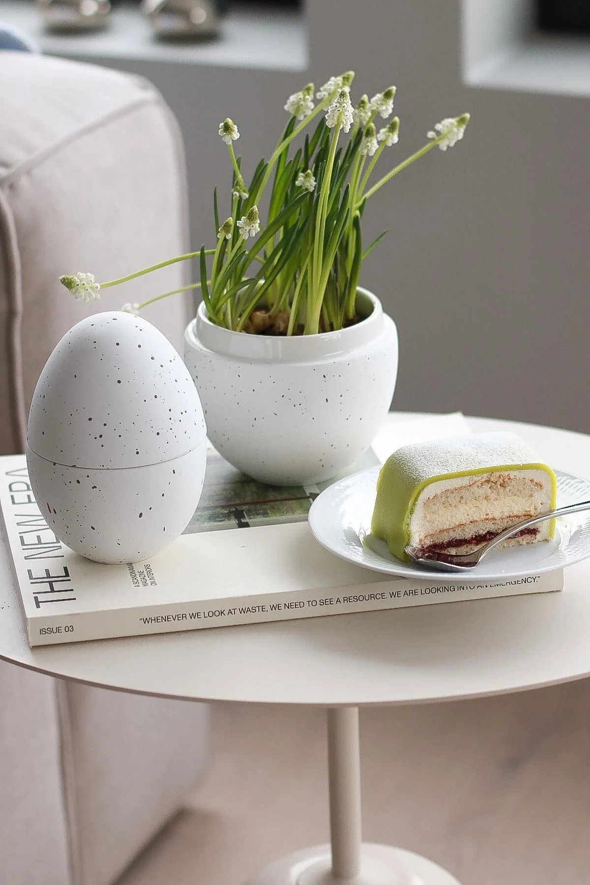 En una mesa auxiliar se encuentra la bombonera blanca con flores de Cooee Design, junto a un plato con una tarta sueca, en el hogar de @picsbyellen