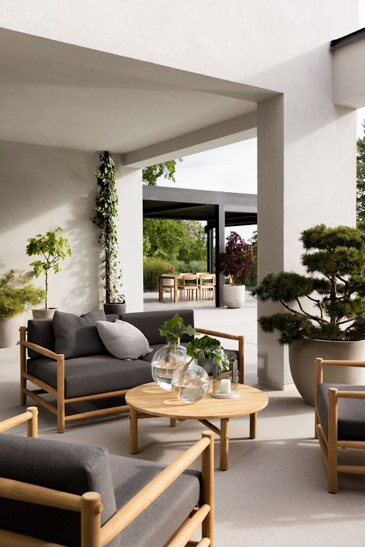 Los muebles de jardín de teca están absolutamente de moda en 2025: aquí puedes ver un grupo de asientos en una terraza, compuesto por la colección Saltholm de Skargaarden.