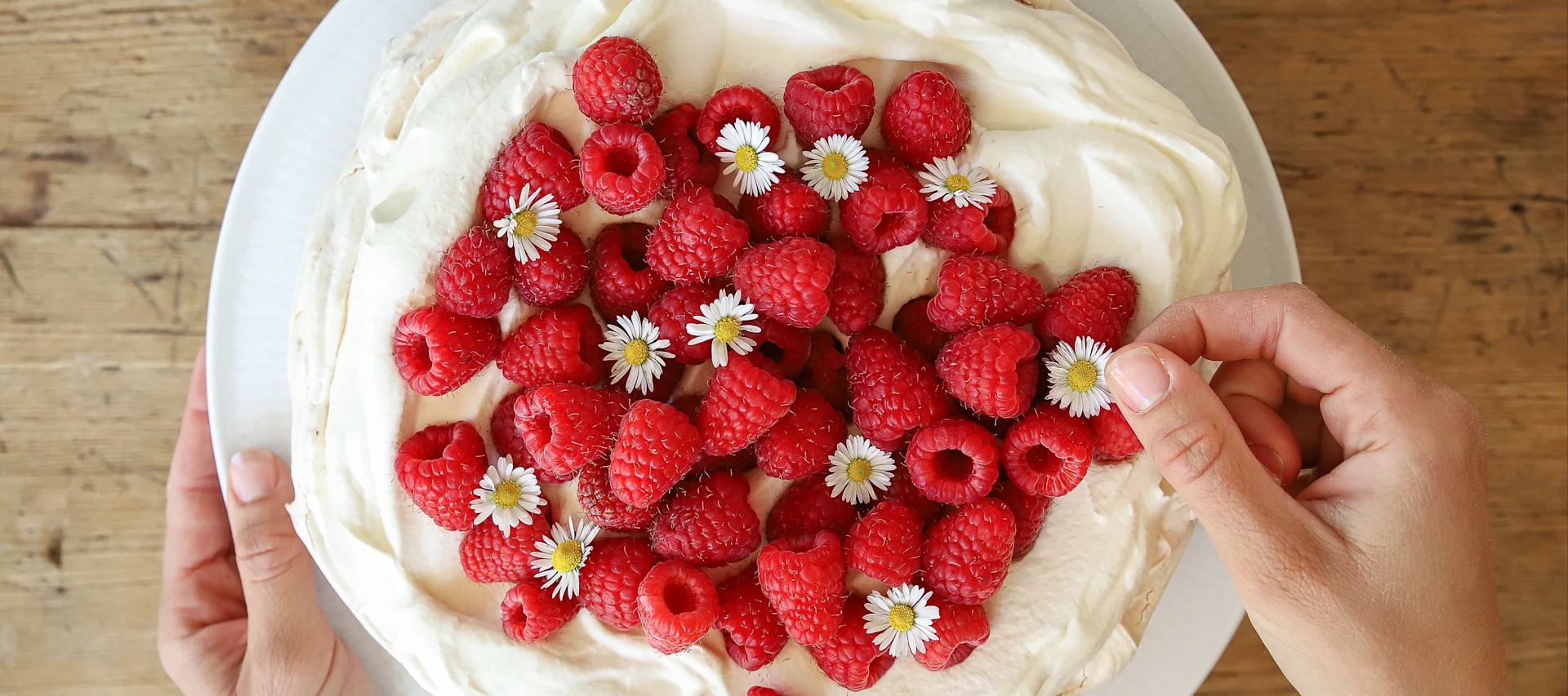 Un delicioso pastel de merengue es una de las sencillas recetas de pasteles de Baka med Frida. Decora el pastel de merengue y nata con frambuesas rojas frescas y margaritas.