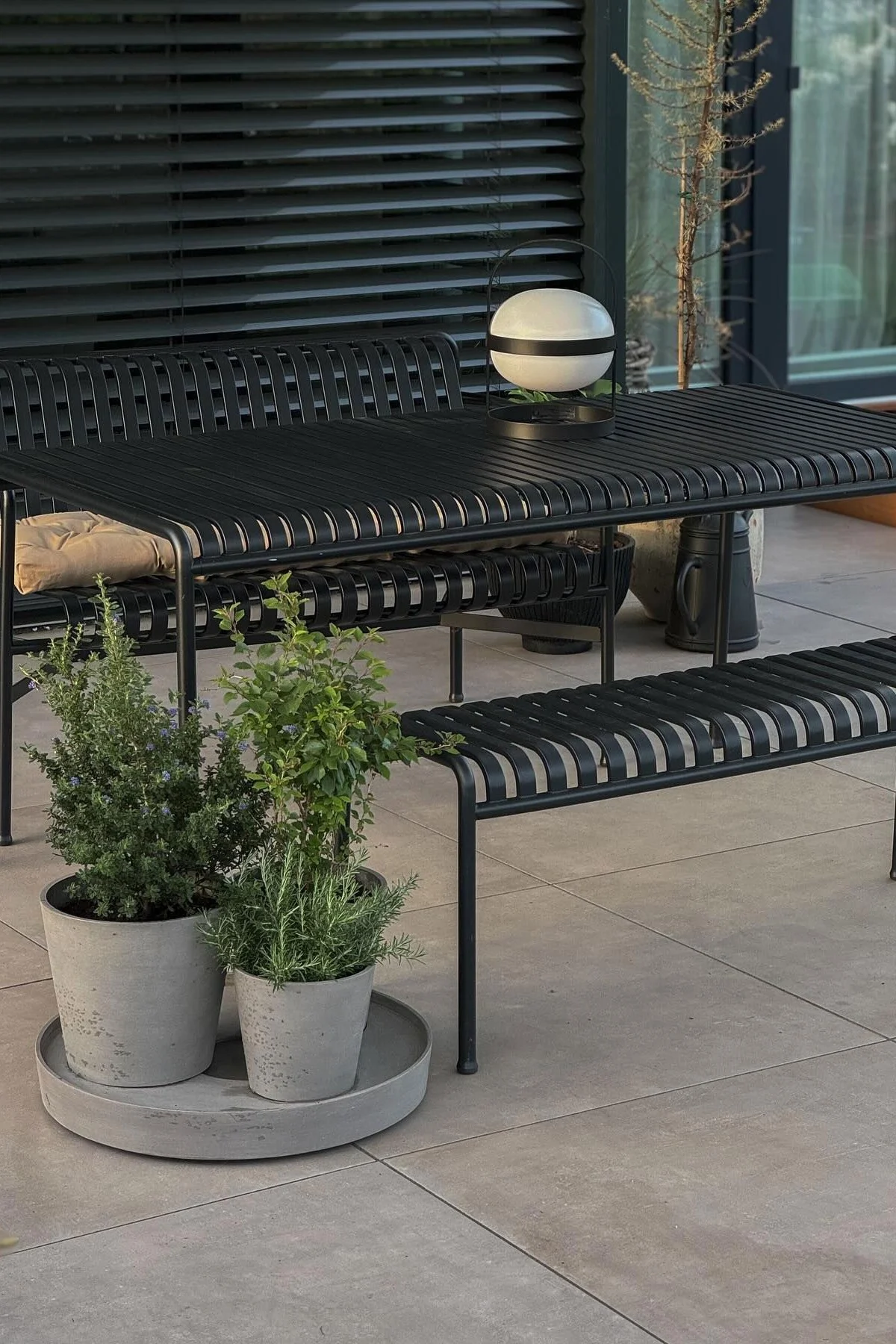 En la terraza de @grauschwarzliebe hay muebles de jardín de la colección Palissade, con macetas con hierbas delante y una lámpara de células solares Soft Spot de Rosendahl sobre la mesa.