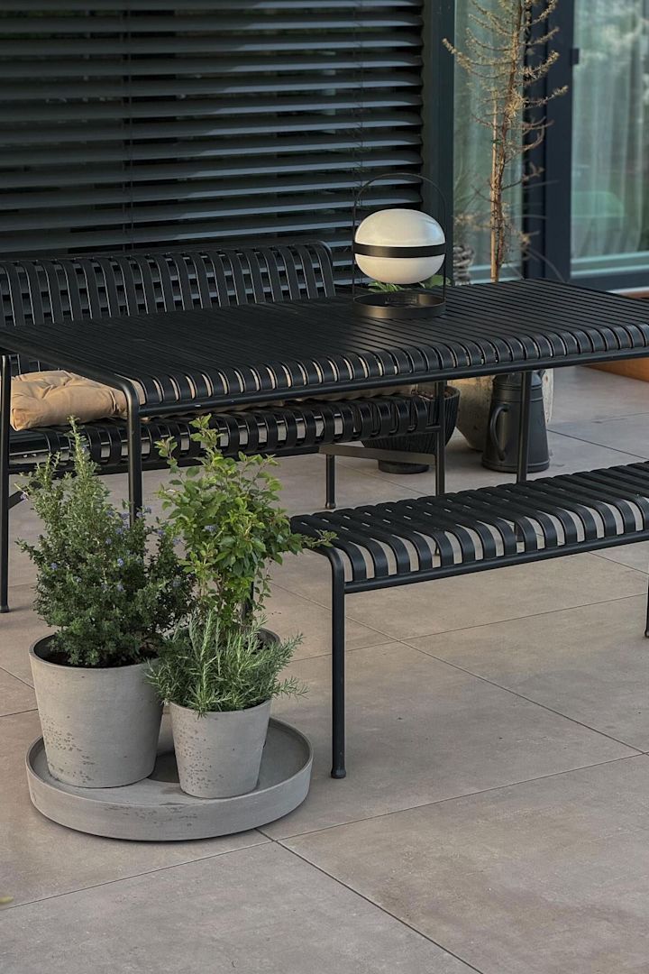 En la terraza de @grauschwarzliebe hay muebles de jardín de la colección Palissade, con macetas con hierbas delante y una lámpara de células solares Soft Spot de Rosendahl sobre la mesa.