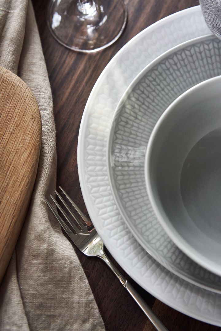 Configuración de mesa con plato Swedish Grace en blanco y cuenco Dimma en gris.