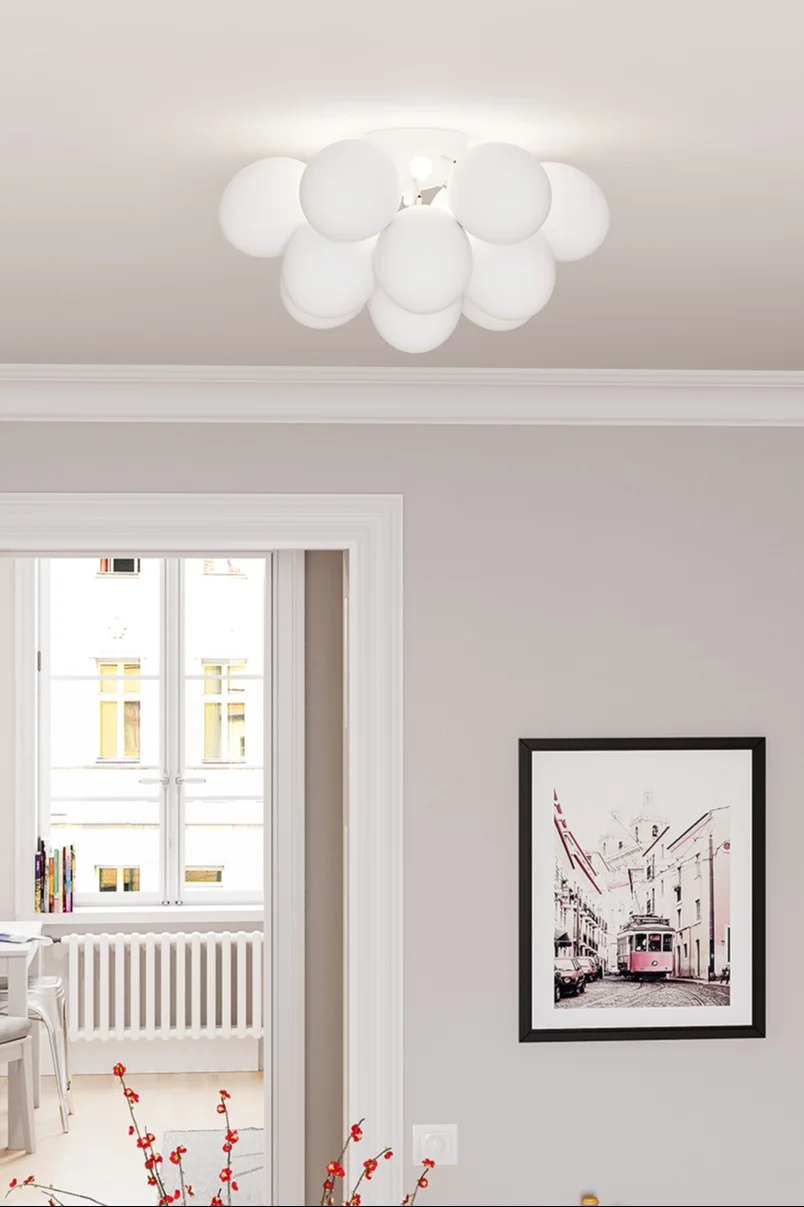 La lámpara de techo grande de By Rydens está instalada en un salón decorado con tonos claros.