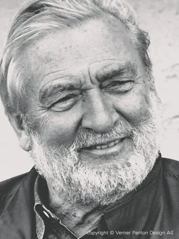 Primer plano, retrato en blanco y negro de un hombre mayor con barba blanca, sonriendo.