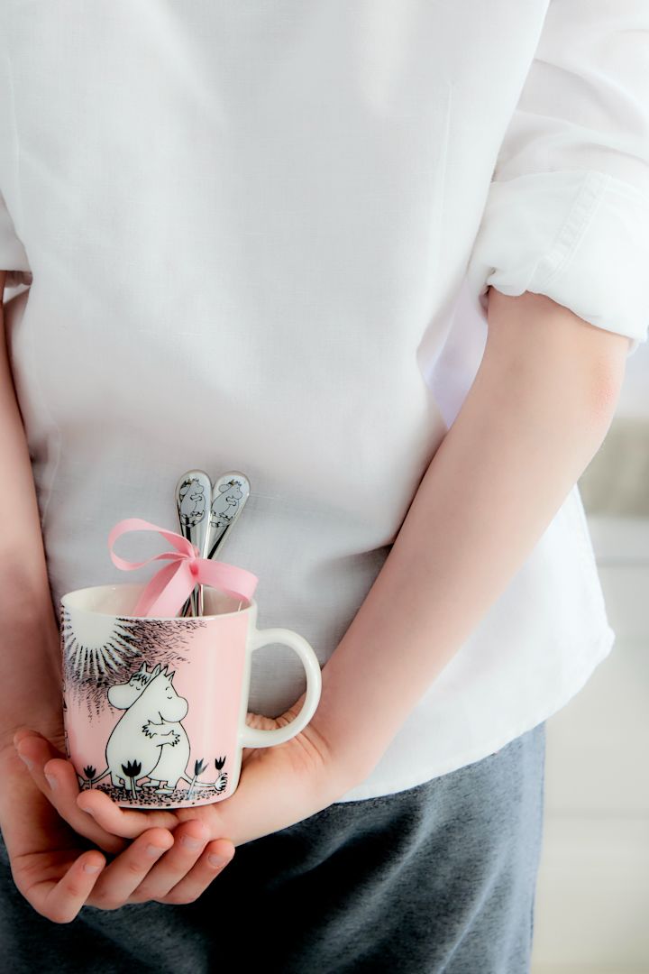 Escondiendo la taza Moomin 'Love' de Moomin Arabia con las cucharas Moomin 'Love' de Hackman tras la espalda.