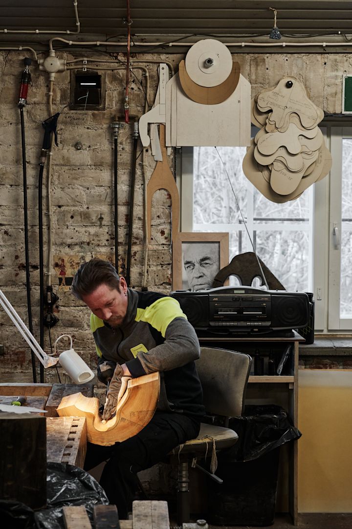 Un hombre talla un molde de madera que se utilizará para crear el jarrón de Alvar Aalto.