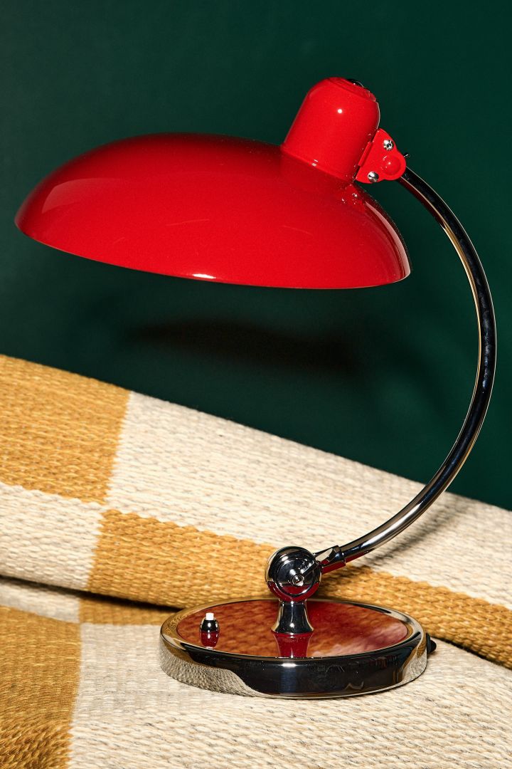 Las tendencias de colores para interiores de 2023 presentan un gran rojo, visto aquí en la atemporal lámpara de mesa Kaiser Idell de Fritz Hansen.