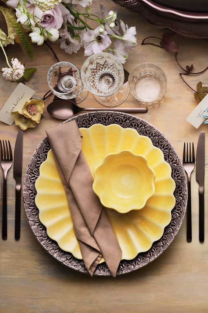 Una mesa puesta con vajilla amarilla de la colección Oyster de Mateus.