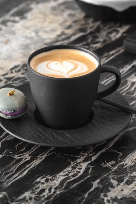 Una taza de café con latte art de espuma de leche encima.