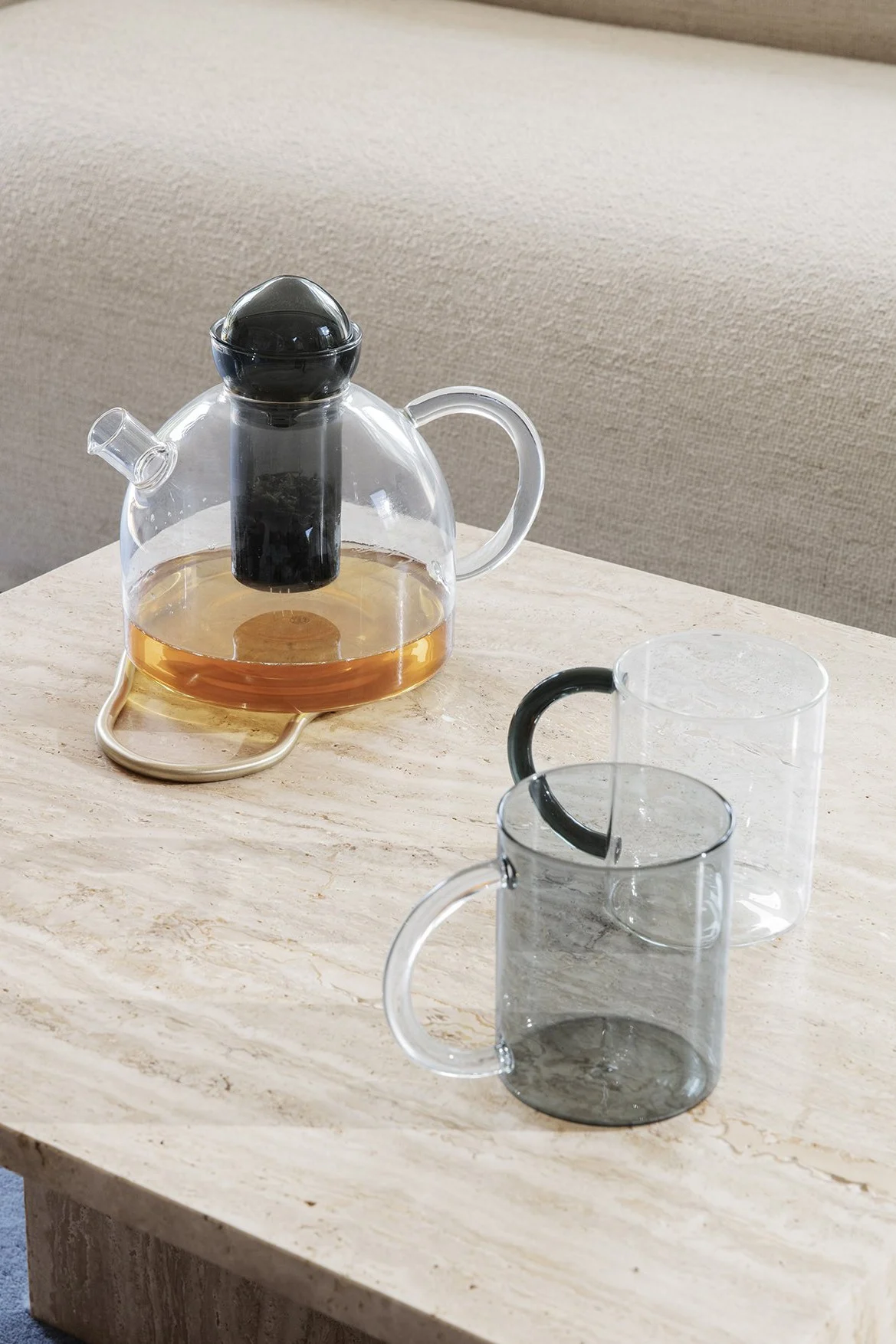 Tetera de cristal con dos tazas de té de cristal.