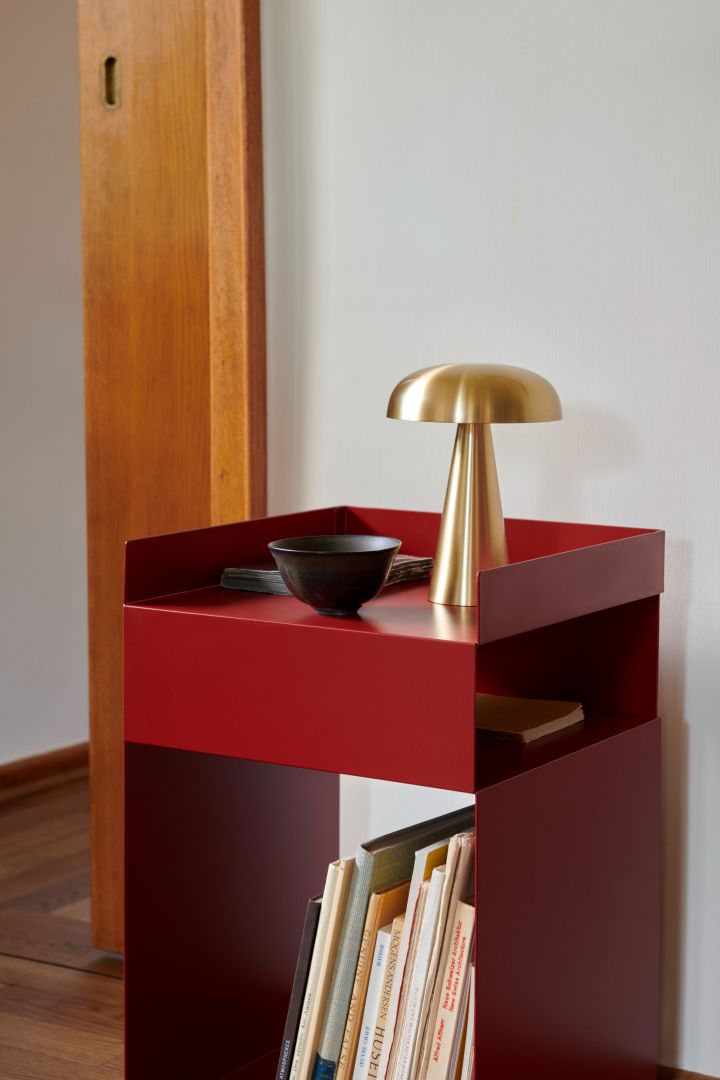 La mesa auxiliar roja Rotate y la lámpara de mesa portátil Como, ambas de &Tradition . 