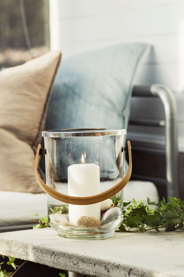 Ilumina tu mesa de exterior con faroles y portavelas, por ejemplo con el farolillo Nature con asa de Sagaform.