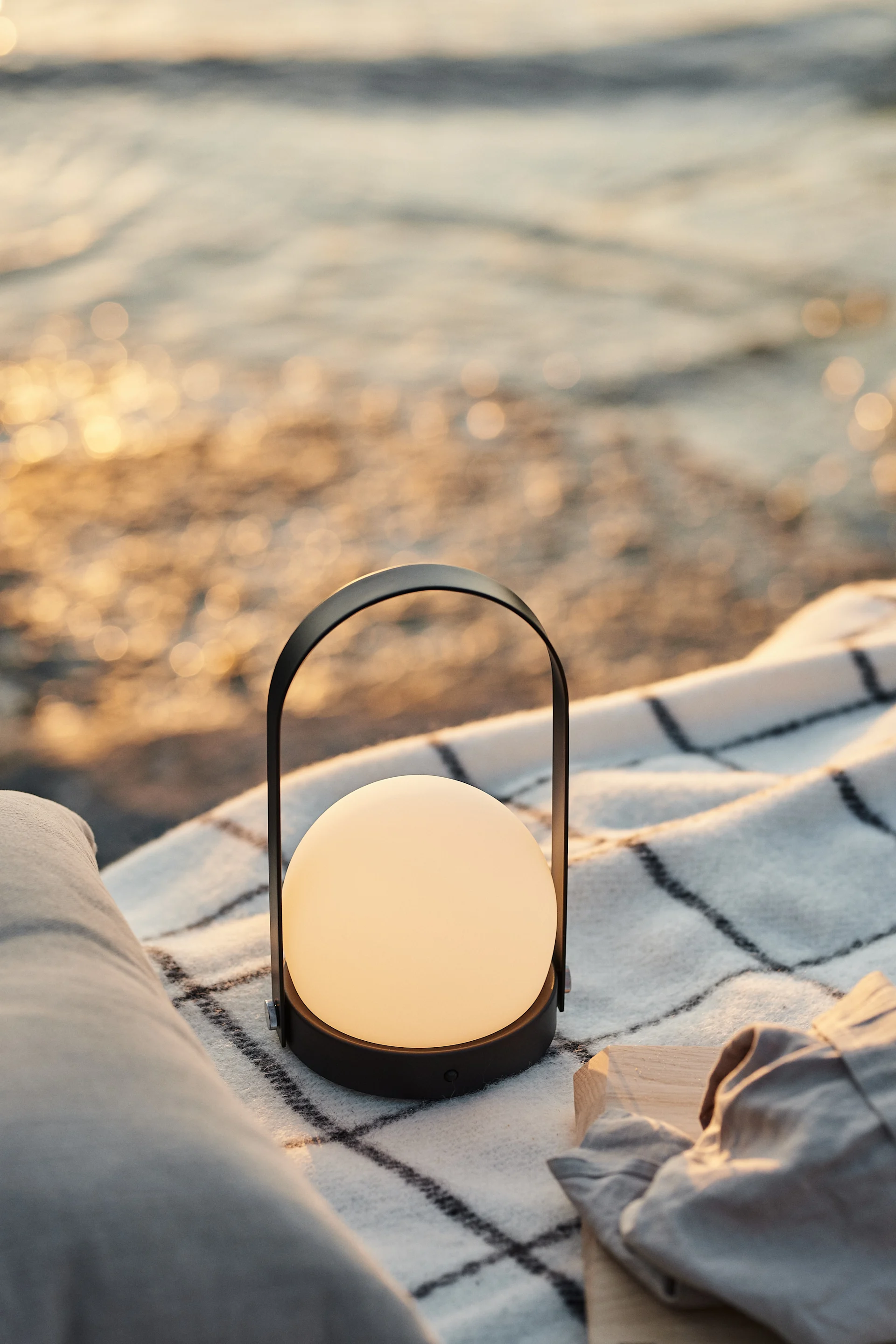 Esta lámpara portátil de Menu, que puedes colocar al atardecer sobre la manta de picnic en la playa para crear un ambiente relajado.
