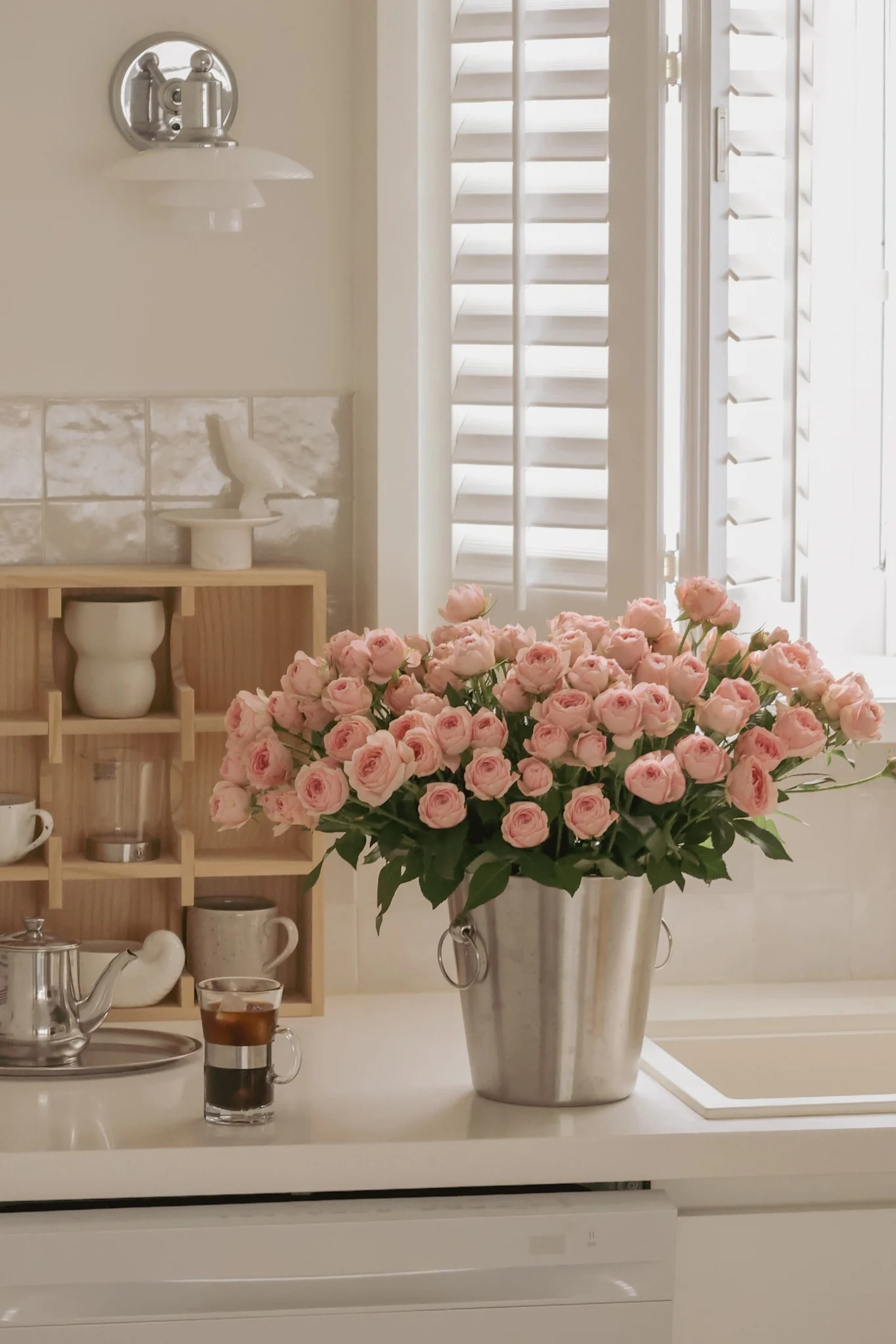 Regalo para San Valentín: el enfriador de vino de Nordwik, acompañado de un ramo de rosas rosas, sobre la encimera de la cocina.