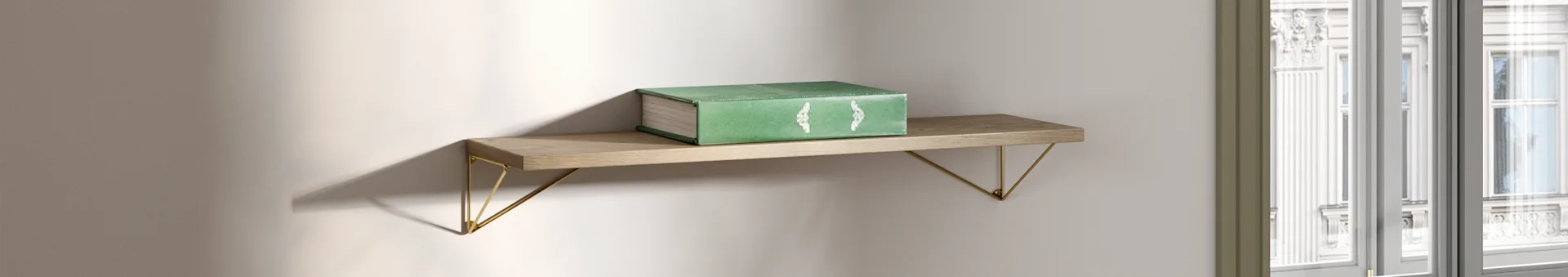 Un libro verde descansa sobre una estantería de madera con soportes dorados, iluminado por luz natural cerca de una ventana.