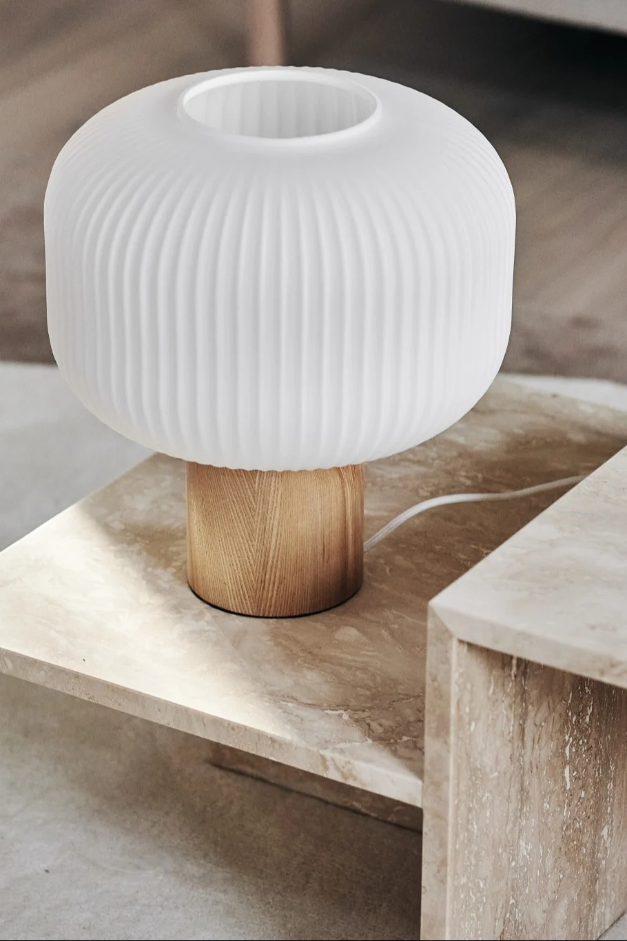 Un mesa de centro de mármol, decorada con la lámpara de mesa Fair de Scandi Living.