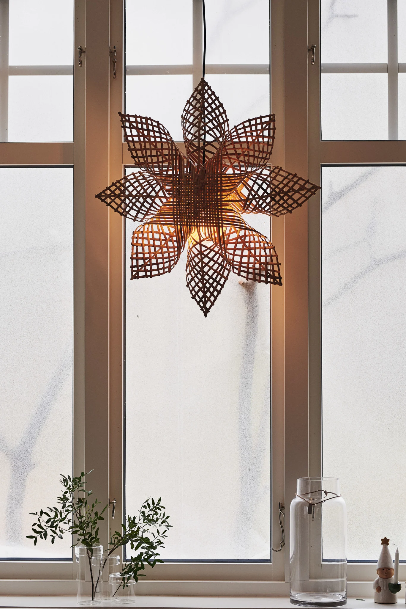 La estrella de Navidad escandinava Carol de PR Home está colgada en una ventana.