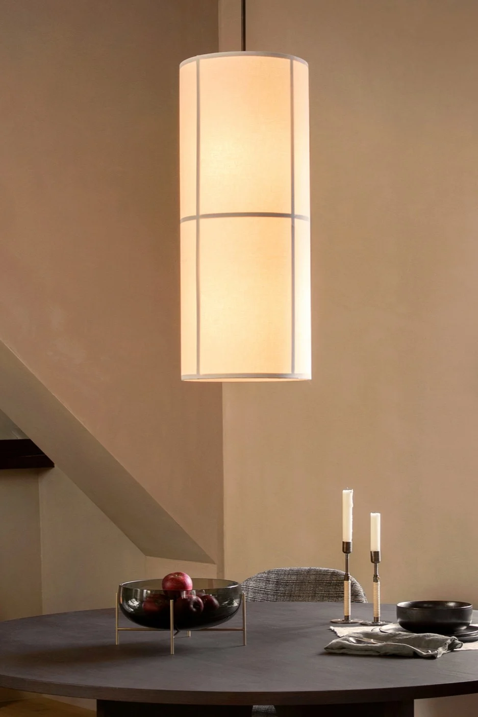 Lámparas escandinavas: la lámpara colgante Hashira de Audo Copenhagen, diseñada al estilo Japandi, cuelga sobre una mesa de comedor.