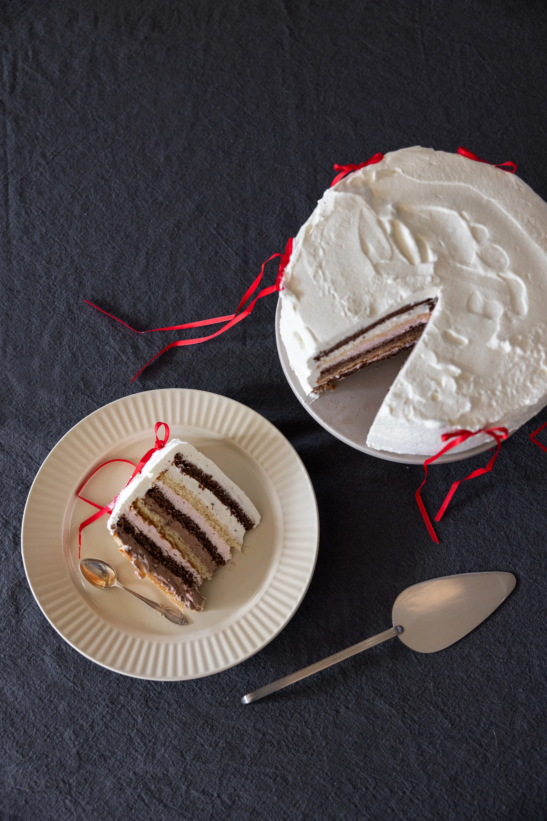 Una tarta de crema en un plato, junto a un trozo de tarta en otro plato de la colección Coffee & More de Sagaform en beige.