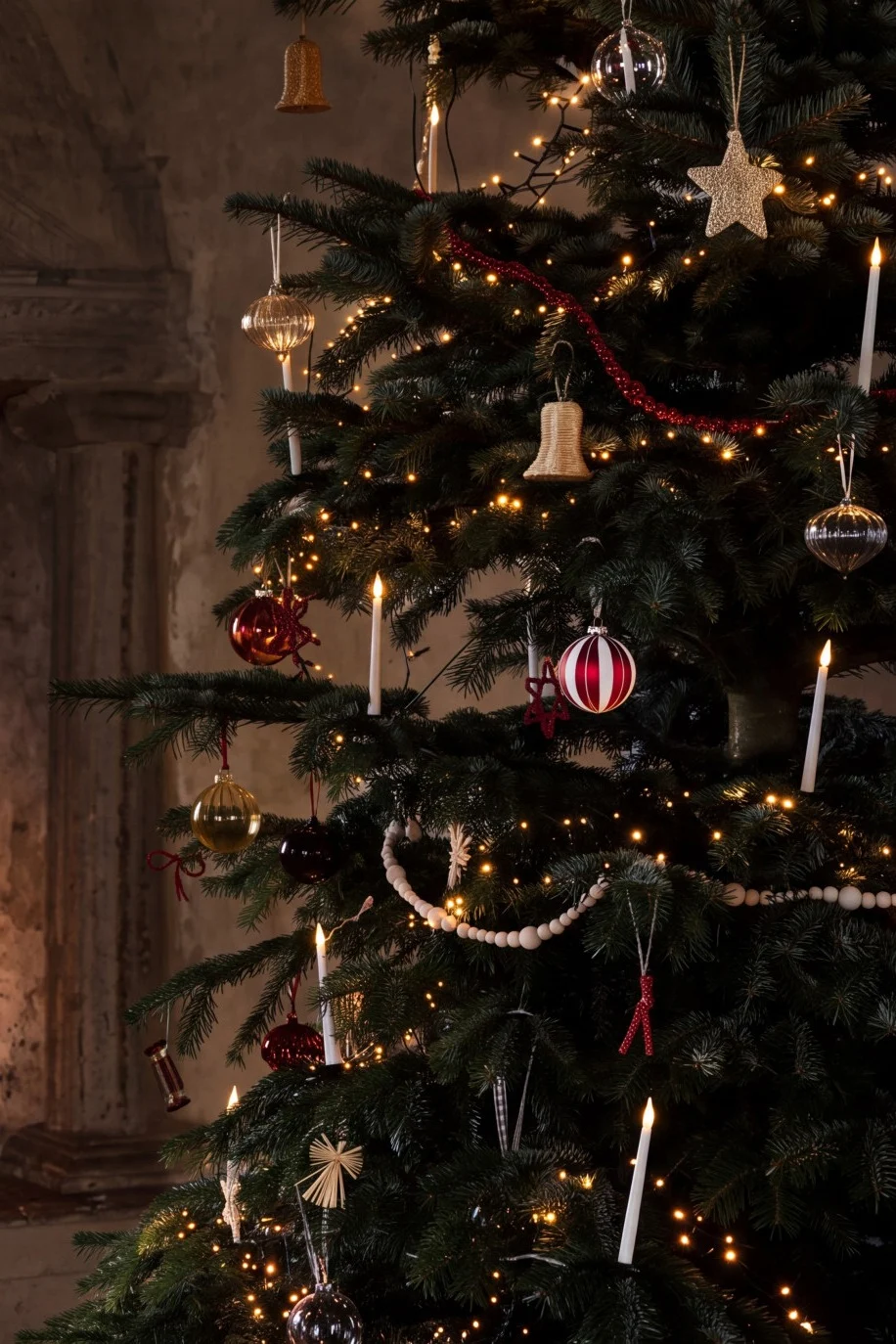 Un árbol de Navidad decorado con luces y adornos junto a una chimenea acogedora con fuego encendido.
