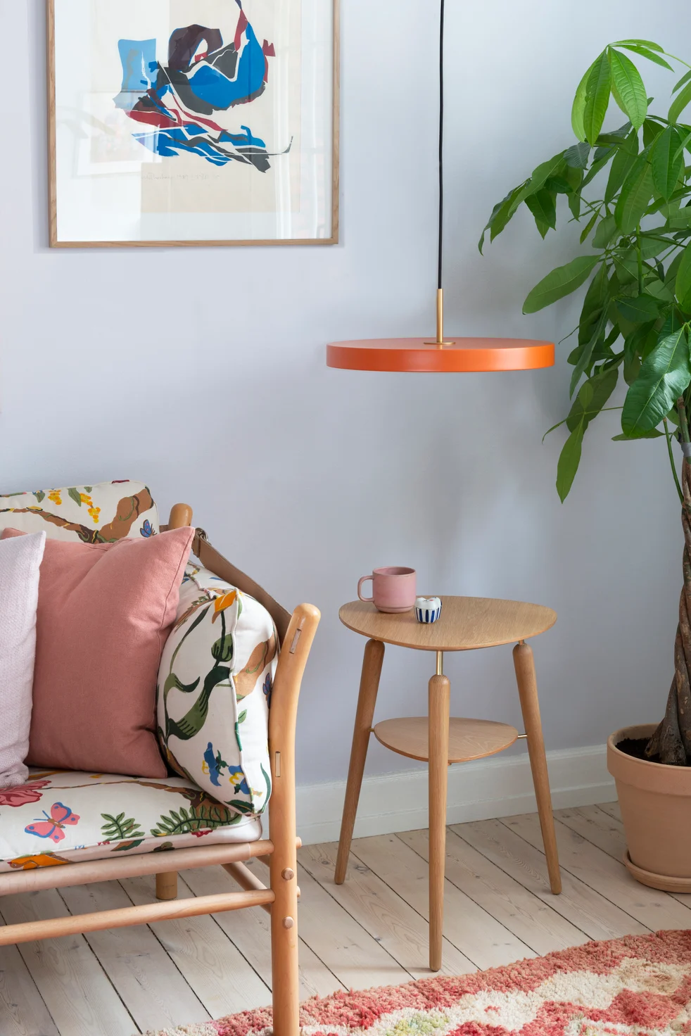 Los tonos anaranjados son perfectos para el estilo boho. Aquí puedes ver un banco con cojines de colores, junto a la mesa auxiliar My Spot y la lámpara colgante Asteria, ambas de Umage.
