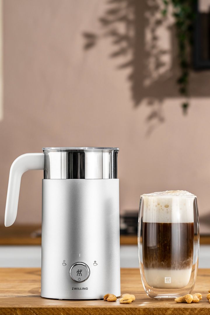 Un espumador de leche eléctrico es el regalo perfecto para los padres que aprecian un buen capuchino, ya que facilita mucho el trabajo. Aquí puedes ver el espumador de leche Zwilling junto a una taza de cappuccino.
