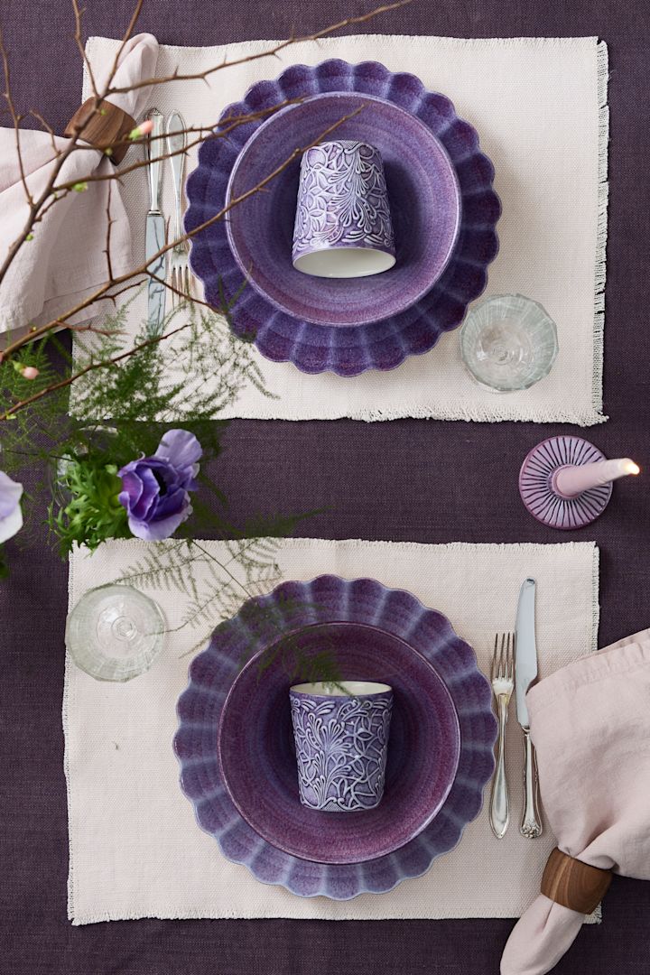 Dos servicios de mesa opuestos en color púrpura, centrados en la taza Lace de Mateus.