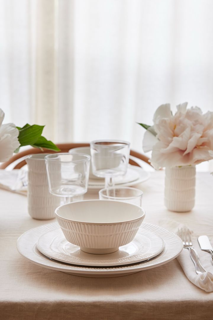 Una mesa puesta de blanco, incluido el bol Stripes en blanco de Mateus.