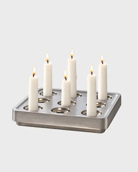 Un candelabro de metal rectangular con seis velas blancas encendidas.