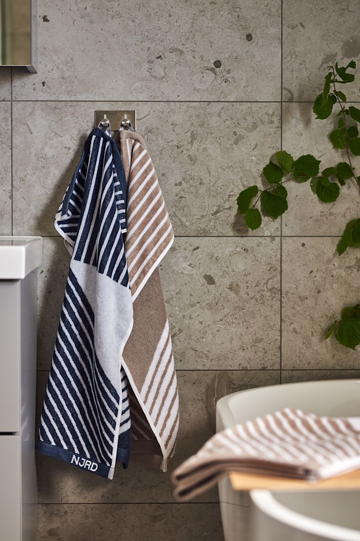 Crea un spa casero en el baño decorándolo con las suaves toallas Stripes de NJRD en beige y azul para momentos de relax.