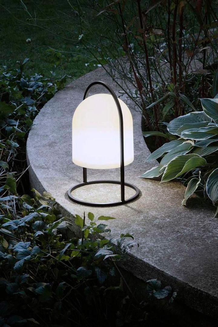 Ilumina los caminos del jardín con farolillos y portavelas para exterior, por ejemplo con la luz solar SunLight de Eva Solo.