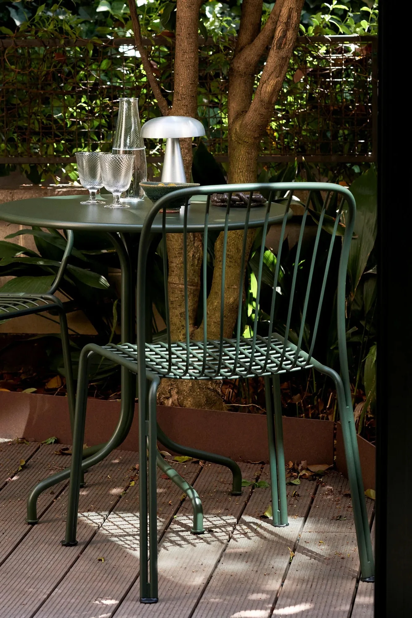 Aquí puedes ver la silla Thorvald de &Tradition, un mueble de exterior ideal para un balcón pequeño. La silla verde de acero lacado no ocupa mucho espacio, pero su diseño es a la vez cómodo y elegante.