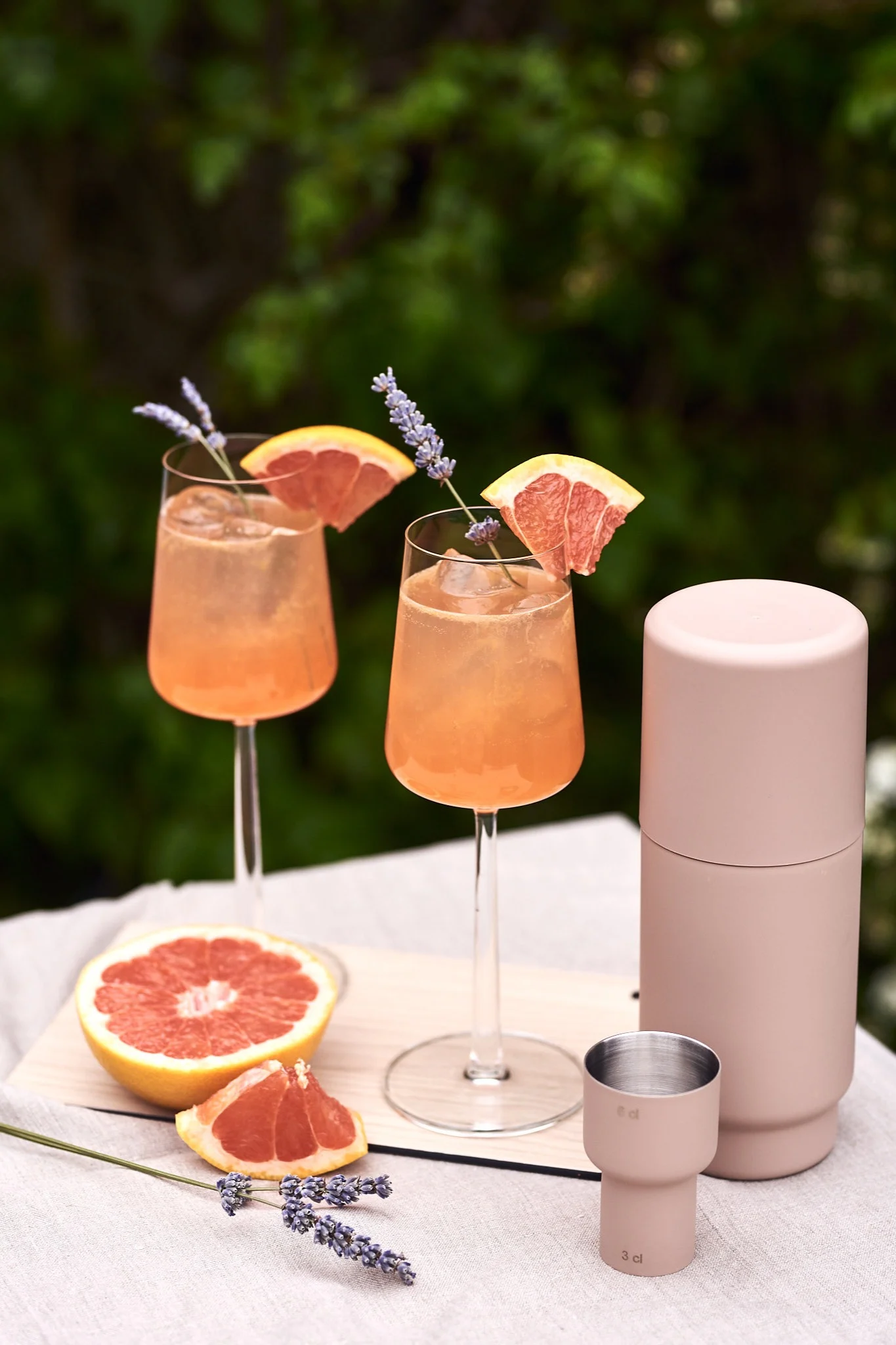 Refrescantes bebidas veraniegas con pomelo en vasos Essence de Ittala sobre una mesa al aire libre.