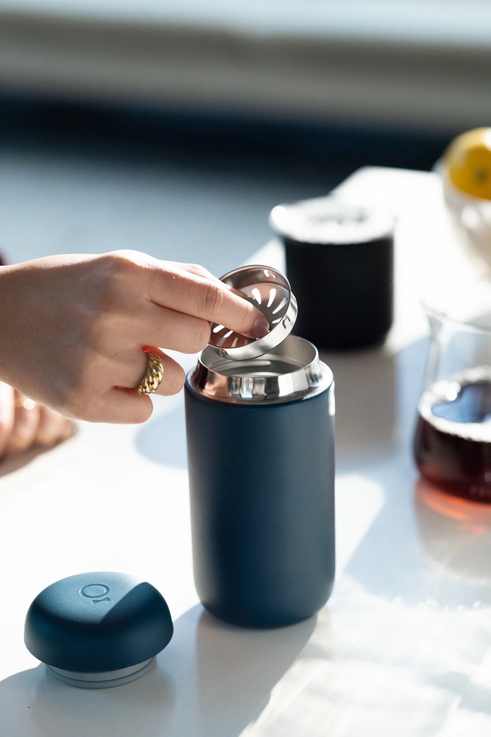 Llévate el café contigo: con la taza térmica Carter azul de Fellow, en la imagen sobre una mesa de cocina.