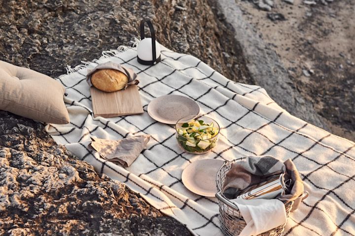 Disfruta de un maravilloso picnic en la playa al atardecer con la lámpara Carrie de Audo Copenhagen.