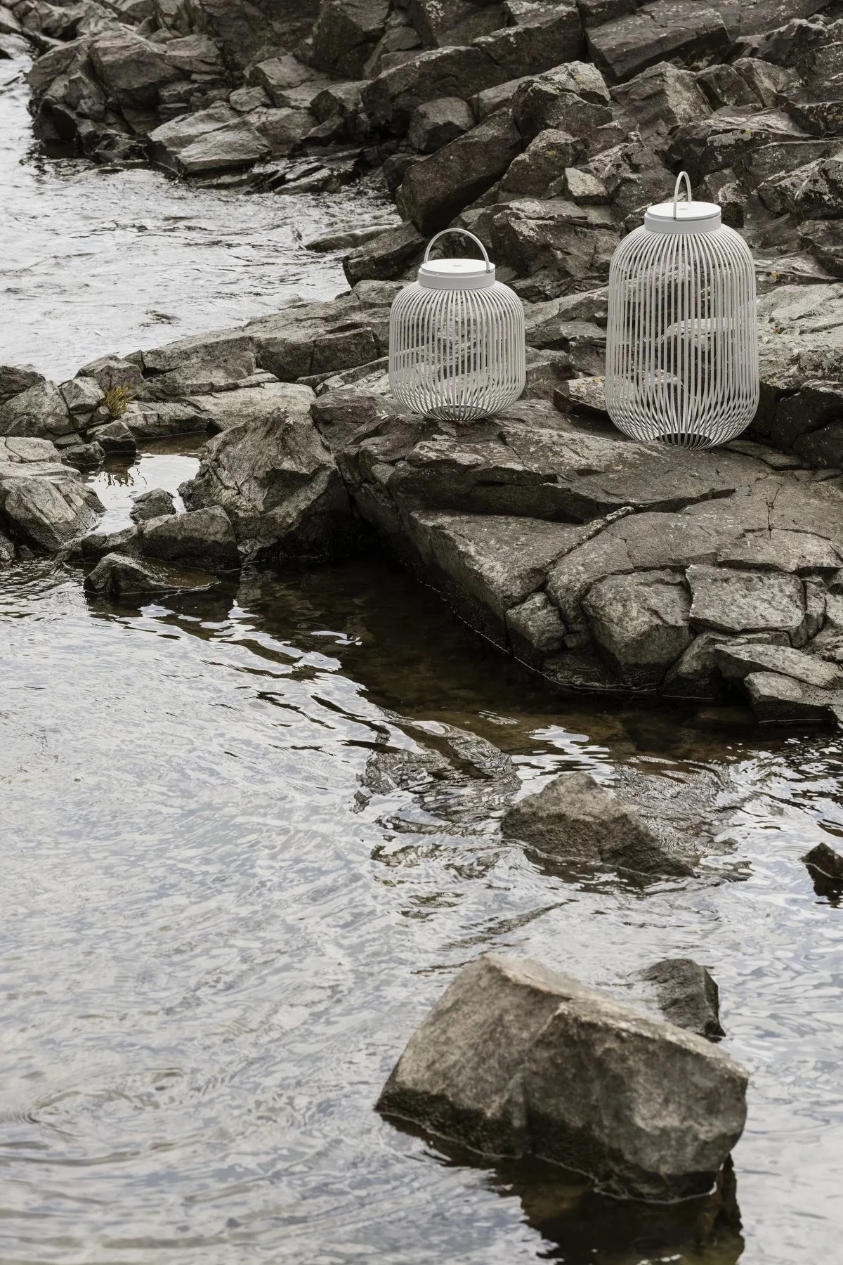 Faroles y linternas para exteriores: aquí puede ver el farol Lito de Blomus en Nomad en varios tamaños de pie en un pasillo.