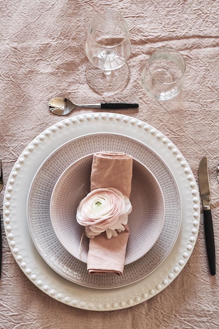 La vajilla rosa es perfecta para una comida romántica en casa, como la porcelana rosa de la colección Swedish Grace de Rörstrand, decorada aquí con una flor.