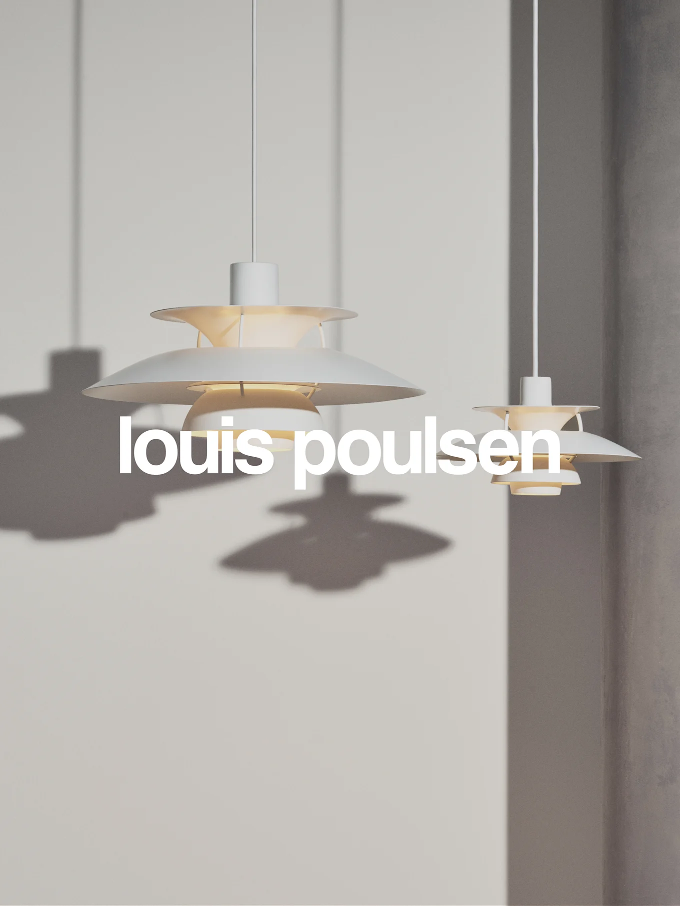 Dos lámparas colgantes blancas y escalonadas cuelgan de una pared gris claro, con el texto 'louis poulsen'.